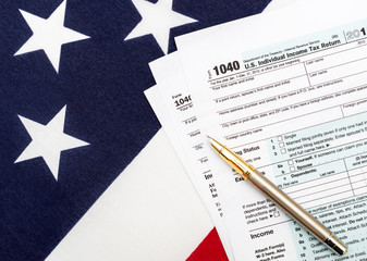 Tax forms with pen on american flag. Business concept. Top view.