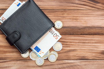 Wallet with euro bills and coins on the table. Top view. Copy space. Business background.