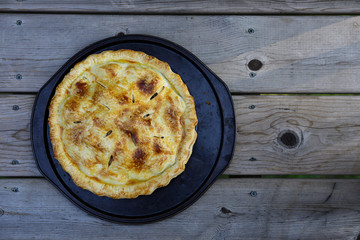 Fresh apple pie just out of the over on dark baking pan