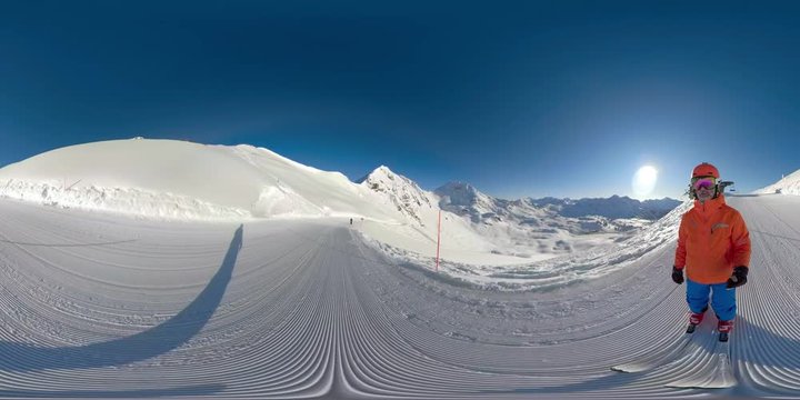 360VR one skier skiing on sunny winter vacation day in mountains with clear blue sky on ski slope and in deep snow falling 
