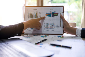 financial Image of two  business people pointing at business document presentation summary report , during discussion at meeting , Notebook on wood table