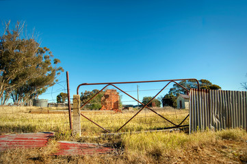 Abandoned property with only a chimney and gate remaining