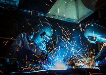 worker with protective mask welding metal
