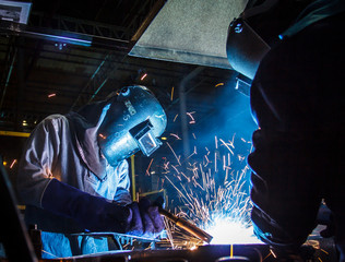 worker with protective mask welding metal