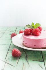Raspberry  cheesecake (cream mousse cake) on  wooden background, copy space.