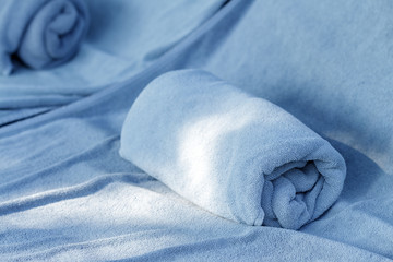 soft and clean rolled bath towels on daybed by swimming pool or beach in hotel or resort