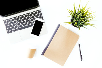 Top view of laptop and smartphone with blank screens on white office desk table.Flat lay