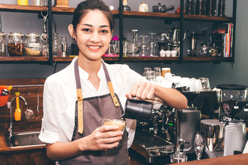 Barista holding milk for make coffee latte art in coffee shop