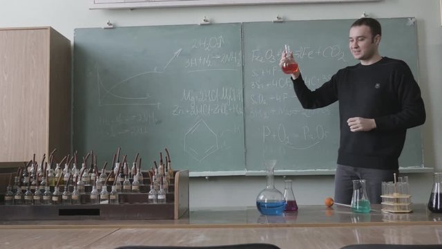 Young professor, docent chemistry of University, College gives lecture to class
