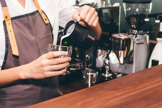 Barista Holding Milk For Make Coffee Latte Art In Coffee Shop