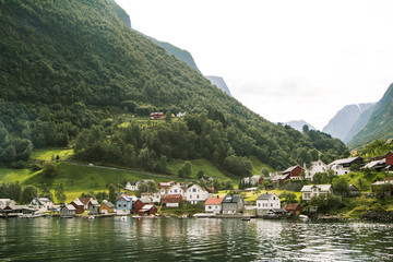 Fototapeta na wymiar Landscape of small village in the mountains next to sea. Sognefjord, Norway