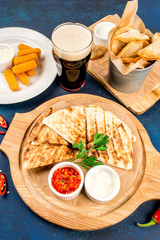 Cheese sticks, beer, empanadas, Mexican quesadilla shot close-up