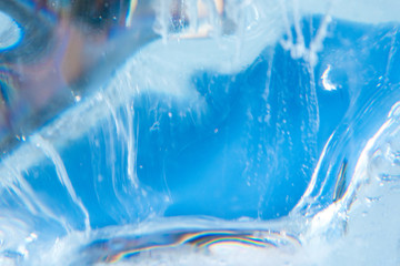 Beautiful blue texture of transparent winter ice with rainbow colors