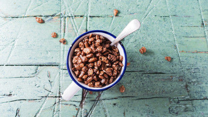 Chocolate rise flakes   in white ceramic cup for breakfast on old cyan wooden table
