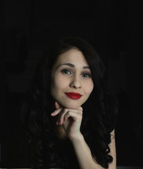 portrait of beautiful young brunette woman on black background