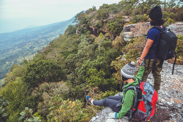 Obraz premium Asian lover women and men travel nature. Travel relax. watch mountain view. On a cliff on the mountain. Thailand