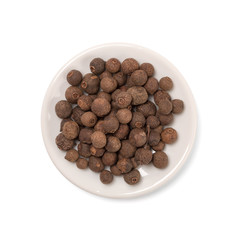 seeds of allspice in a white bowl on a white background