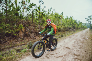 Fototapeta na wymiar Asian women Travel photograph Nature. Travel relax ride a bike Wilderness in the wild. Thailand