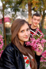 Beautiful girl with long, bright hair in an embroidered Ukrainian shirt walks with a guy in the spring