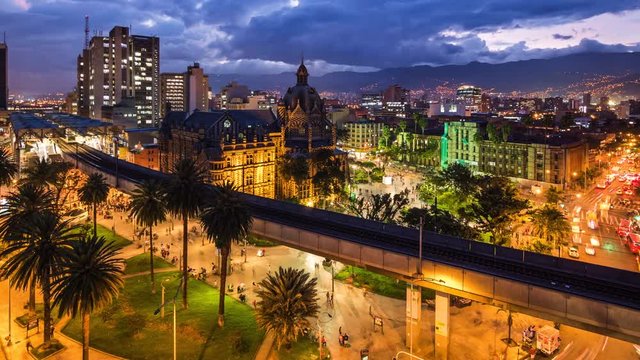 Medellin, Colombia, time lapse view of downtown buildings and Plaza Botero square at dusk. Zoom out.