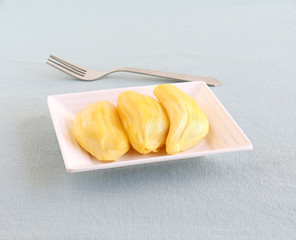 Jackfruit arils, or bulbs, which are said to be nutritious and offer health benefits, and a steel fork.