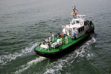 Tugboat sailing in the sea. Tugboat making maneuvers.