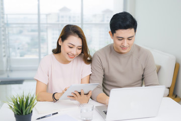 Happy businesswoman and businessman using laptop at workplace in office