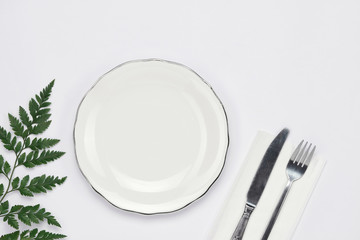 Dinner plate setting top view. Empty plate and silverware set on wooden table