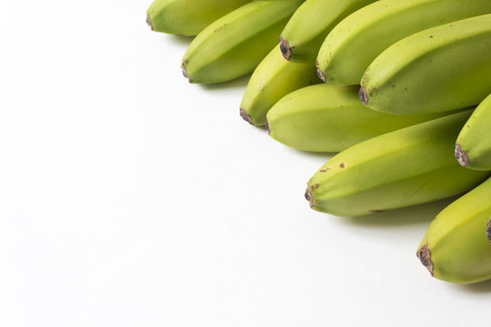 Diagonal composition of green and yellow baby bananas, good copy space, horizontal aspect