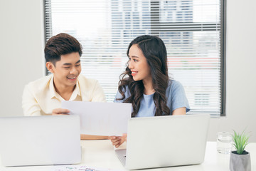 Young business team working together at a laptop, man and woman