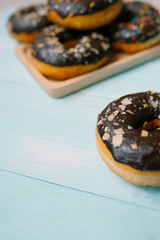 Chocolate donuts on blue background. Top view with copy space