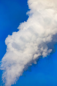 smoke from a pipe in the factory against a blue sky