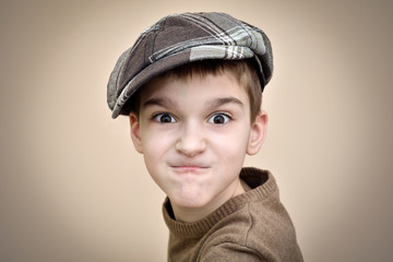Portrait of an angry young boy with cap. Vintage style.
