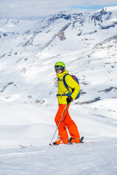 Photo of sporty man wearing helmet skiing against backdrop of snowy mountains