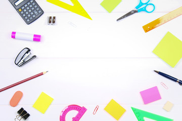 Empty space surrounded by stationery on a white wooden table. Copy the space.