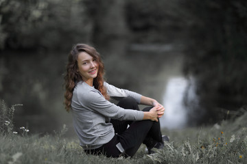 young woman sitting near the river