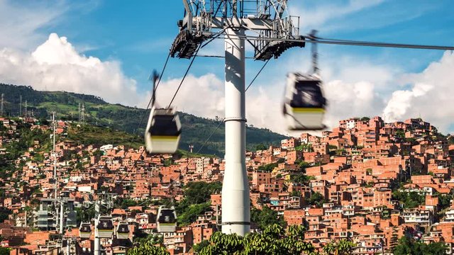 Medellin, Colombia, time lapse view of the iconic Metrocable (cable car) system over Comuna 13 slums during daytime. Dolly left to right.