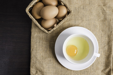 Fresh egg in white cup on cloth background.