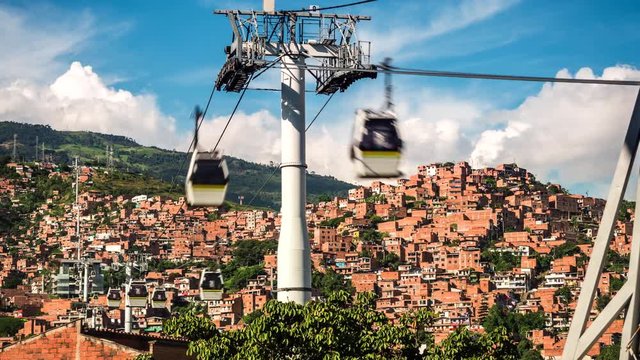 Medellin, Colombia, time lapse view of the iconic Metrocable (cable car) system over Comuna 13 slums during daytime. Zoom in.