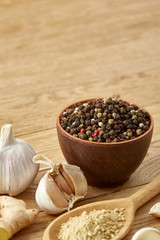 Composition of powder spices on spoon and different sorts of spicies on wooden table background, selective focus