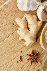 Composition of powder spices on spoon and different sorts of spicies on wooden table background, selective focus