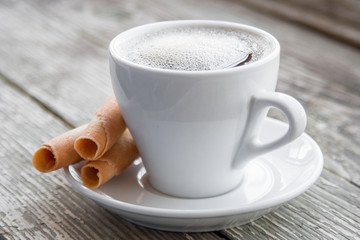 White cup of coffee on a natural old wooden background with biscuits. Selective focus. With copy space