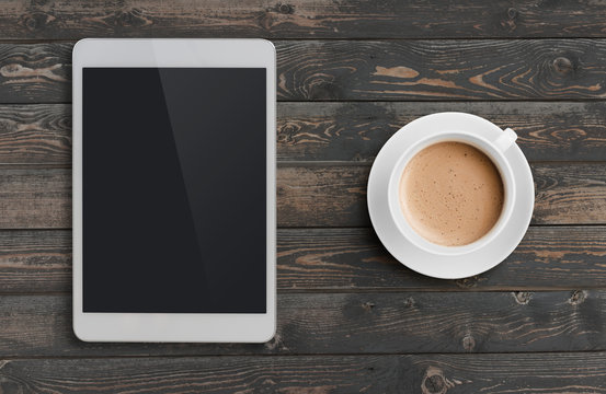 Coffee Cup And Tablet Pc Similar To Ipad On Dark Wooden Table Top View