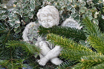 A small figure of an angel covered with fir branches