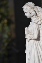 Sculpture of a praying angel on a tomb