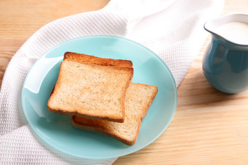Plate with tasty toasted bread on table