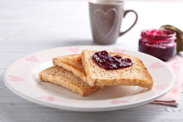 Plate with tasty toasted bread and jam on table