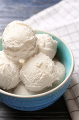 Fototapeta na wymiar Bowl with delicious vanilla ice cream, closeup