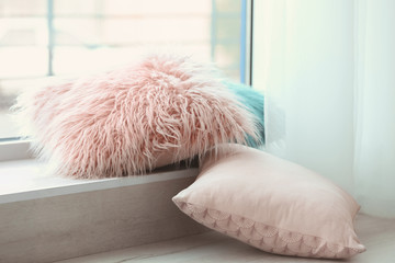Different pillows on windowsill