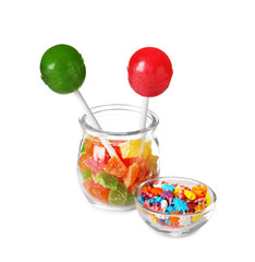 Glassware with different colorful candies on white background
